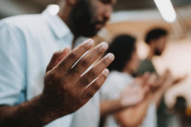 Hands joined in prayer during a prayer meeting